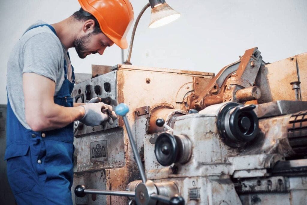 Worker performing maintenance on industrial equipment, highlighting the benefits of asset tracking for equipment rentals