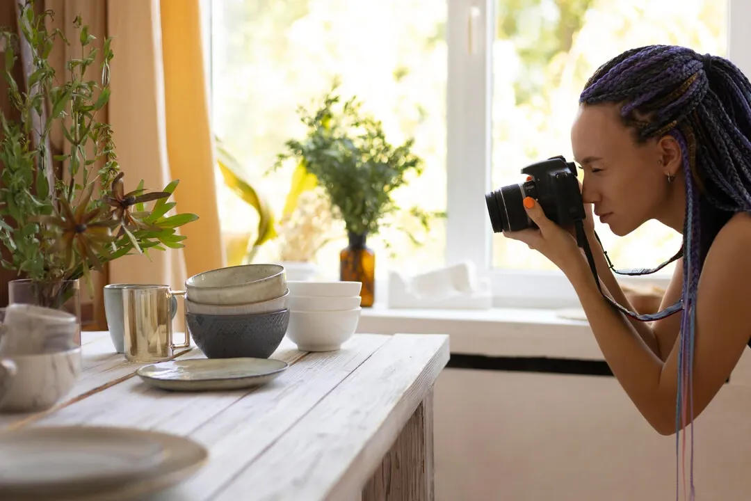 A professional capturing a food table setup with natural light for high-quality photography
