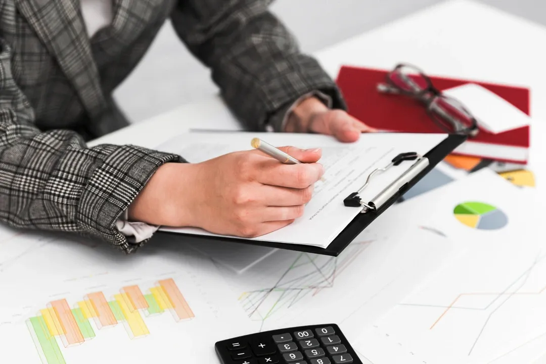 Individual reviewing documents and charts, crucial for creating a car rental business plan